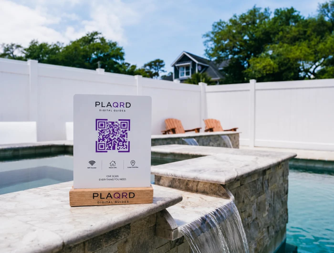A Plaqrd acrylic plaque with a QR code, displayed poolside at a vacation rental